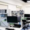 A contemporary computer lab with advanced workstations and electronic equipment, perfect for research and development.