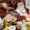 Close-up of hands crafting with colorful paper, glitter, and ribbons; perfect for DIY art projects.