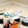 A collection of painting tools and materials for home renovation, featuring paint rollers and a bucket.