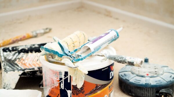 A collection of painting tools and materials for home renovation, featuring paint rollers and a bucket.