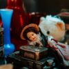 Charming vintage setup featuring a doll, toy camera, and decorative glassware, captured with warm tones.