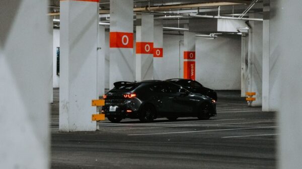 A stylish black sports car parked in a modern, empty urban parking garage.