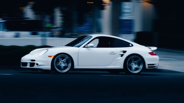 A dynamic shot of a white Porsche in motion on a street in San Diego, capturing speed and elegance.