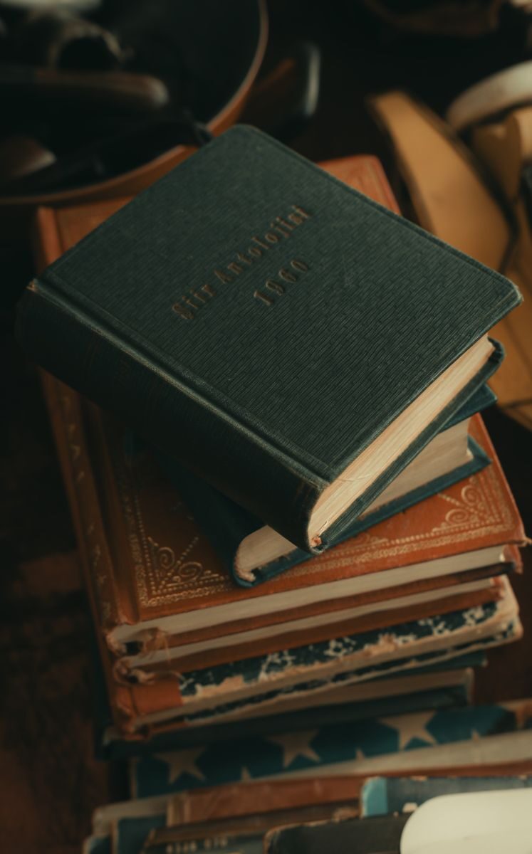 A vertical shot of a stack of vintage books with leather covers, perfect for literary themes.