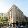 A classic corner building in Washington DC with cars, captured during a sunny day.