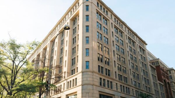A classic corner building in Washington DC with cars, captured during a sunny day.