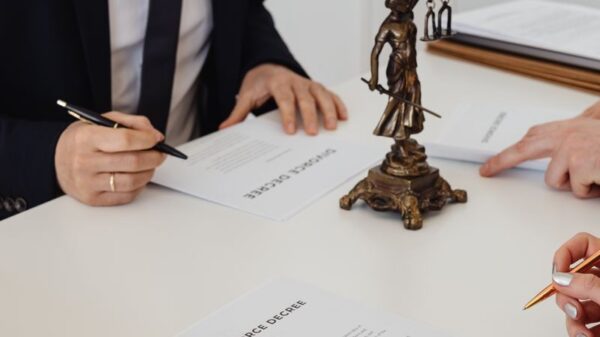 Lawyers reviewing and signing divorce decree documents in a formal office setting.
