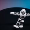 A futuristic white robot toy performing on a sleek dark surface.
