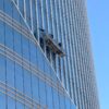 Professional window cleaners suspended on a high-rise building facade.