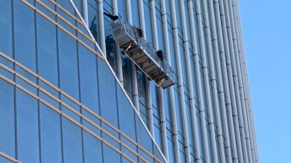Professional window cleaners suspended on a high-rise building facade.
