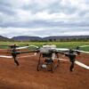 Aerial drones in a field, showcasing modern agricultural technology and landscape.
