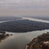 Stunning aerial shot of the river bend in Belgrade, Serbia, showcasing lush greenery and cityscape.