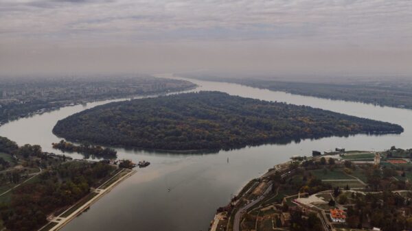 Stunning aerial shot of the river bend in Belgrade, Serbia, showcasing lush greenery and cityscape.