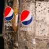Refreshing close-up of two empty Pepsi glasses covered in water droplets, shot indoors.