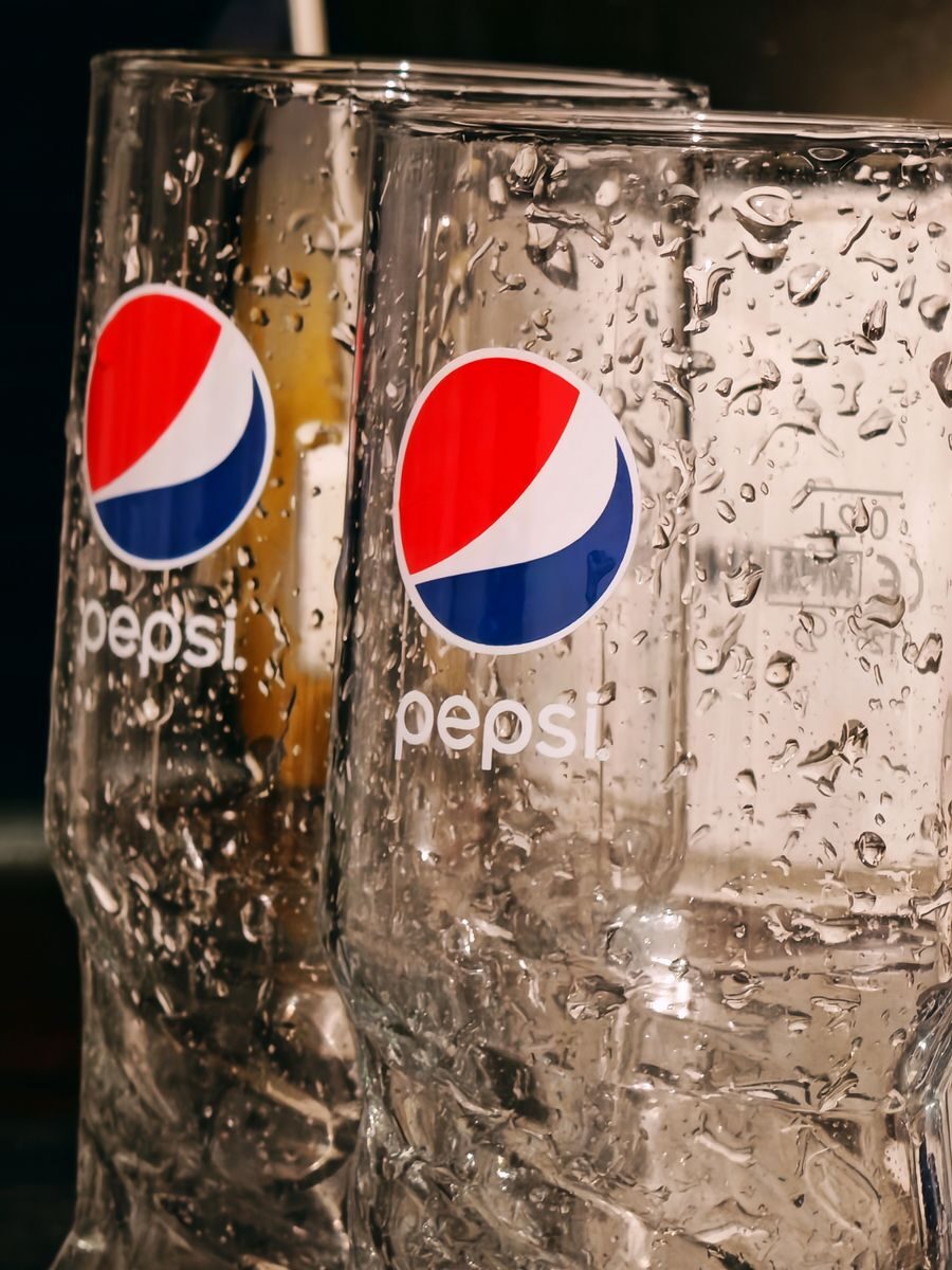 Refreshing close-up of two empty Pepsi glasses covered in water droplets, shot indoors.