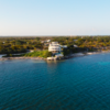 A scenic aerial view of a luxury beachfront estate in Grand Cayman with lush greenery and azure waters.