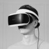 Black and white close-up of a man wearing a virtual reality headset indoors.