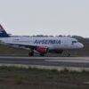 Air Serbia aircraft taxiing on runway, ready for takeoff.