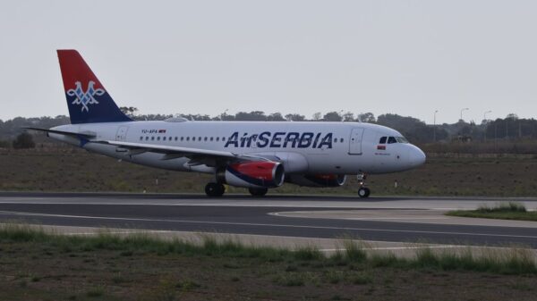 Air Serbia aircraft taxiing on runway, ready for takeoff.