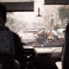 View of a busy urban street with congested traffic seen from a bus windshield.