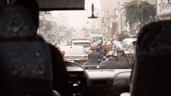 View of a busy urban street with congested traffic seen from a bus windshield.