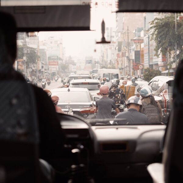 View of a busy urban street with congested traffic seen from a bus windshield.