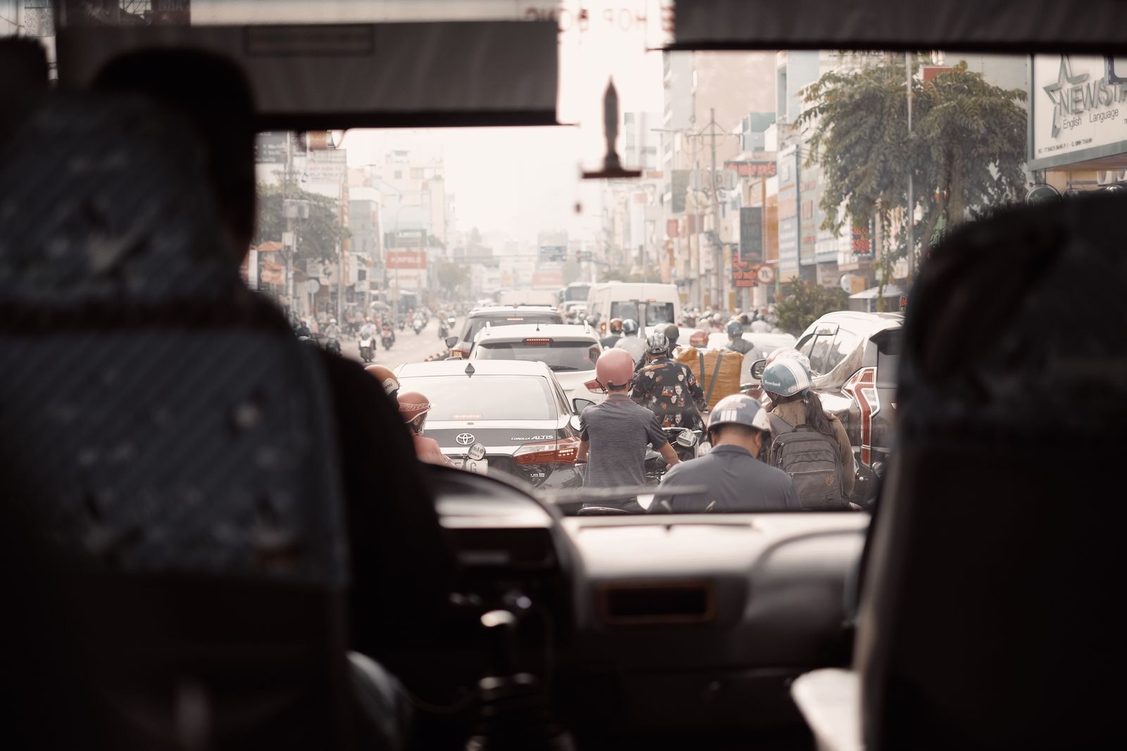 View of a busy urban street with congested traffic seen from a bus windshield.