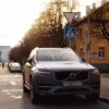A Volvo XC90 parked on a city street with a beautiful sunlight backdrop.