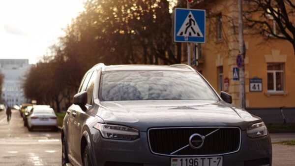 A Volvo XC90 parked on a city street with a beautiful sunlight backdrop.