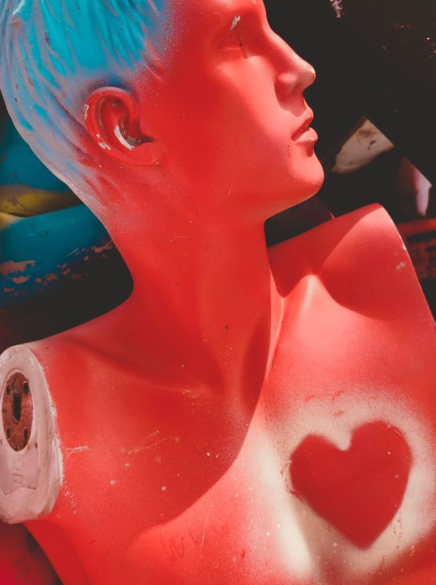 Vibrant mannequin torso with blue hair and heart design, perfect for artistic themes.