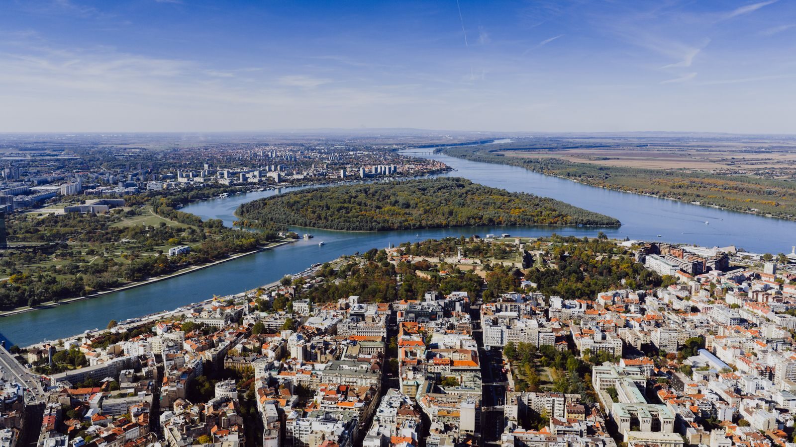 Aerial view showcasing the cityscape of Belgrade, Serbia with the Danube River winding through the landscape.