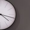 white analog wall clock at 11 00