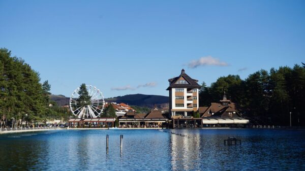 Serene lake view in Zlatibor, Serbia, featuring a Ferris wheel and vibrant landscape, perfect for travel imagery.