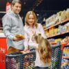 A happy family shopping together in a supermarket aisle, sharing a joyful moment.