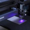 Close-up of a CNC laser engraving machine processing a wooden piece.