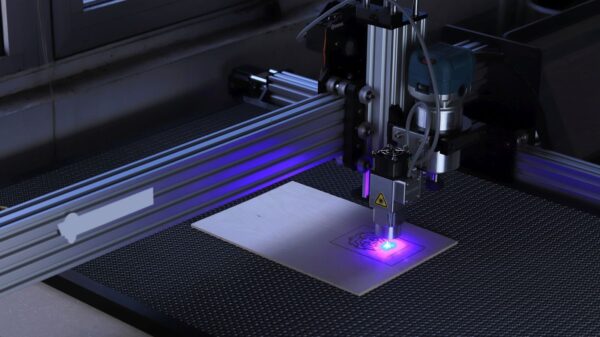 Close-up of a CNC laser engraving machine processing a wooden piece.