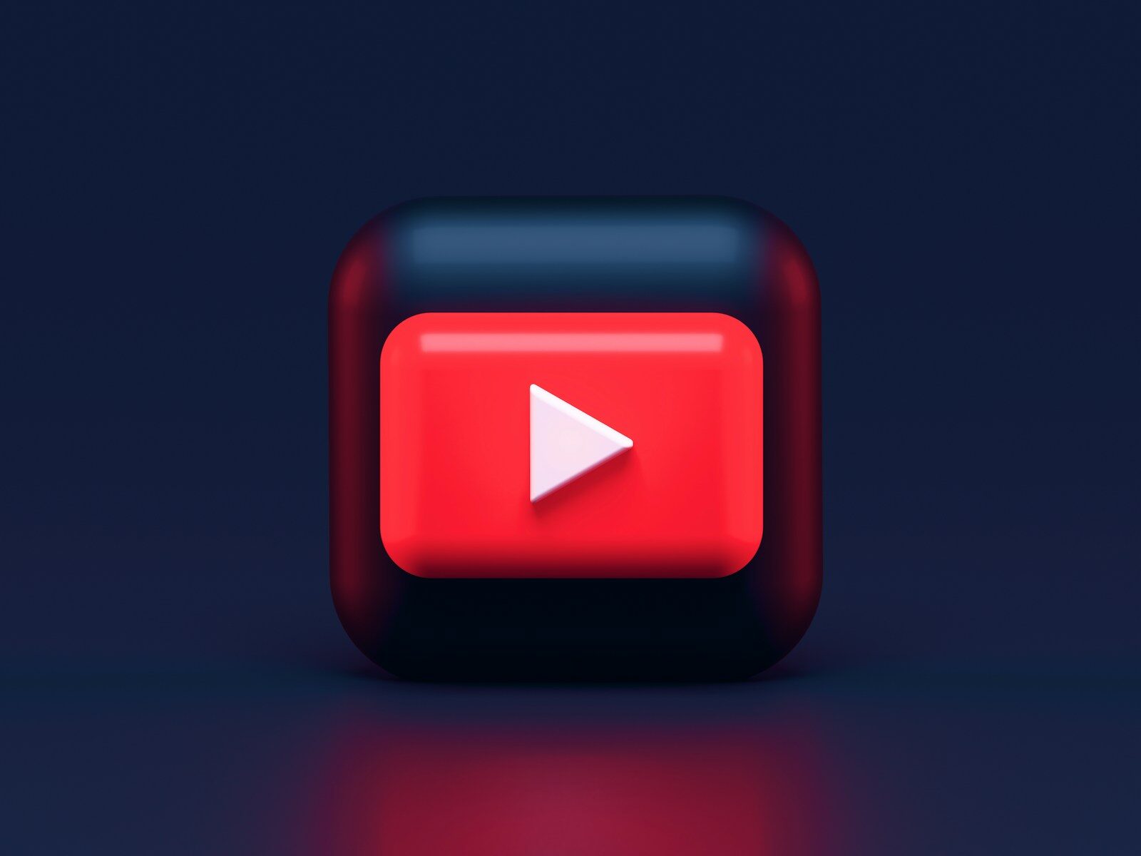 A 3D red play button icon on a dark blue background