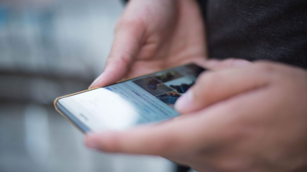 Close-up of hands using a smartphone with a touchscreen, emphasizing mobile technology.