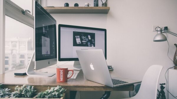 Sleek home office setup with dual monitors, a laptop, and minimalist decor.