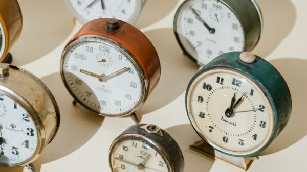 Assorted vintage alarm clocks in warm light showcasing timeless elegance.