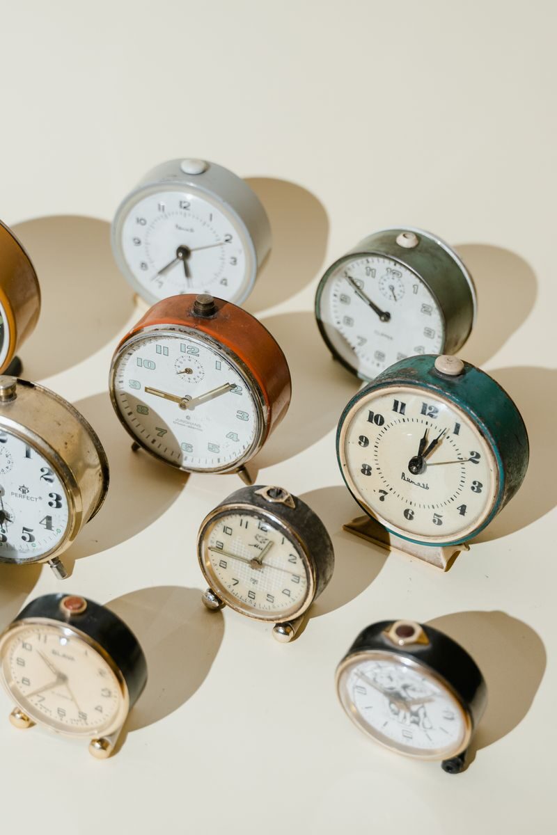 Assorted vintage alarm clocks in warm light showcasing timeless elegance.