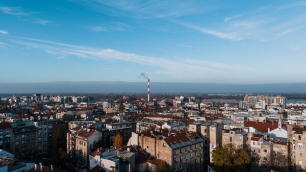 Aerial cityscape of Beograd, Serbia featuring urban skyline and smokestack.