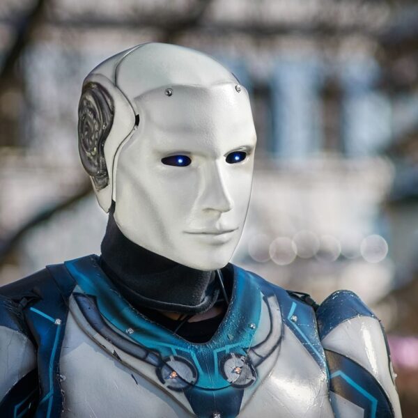 Close-up of a futuristic humanoid robot with metallic armor and blue LED eyes.