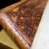 Detailed close-up of an antique leather bound book with ornate engraving and aged paper.
