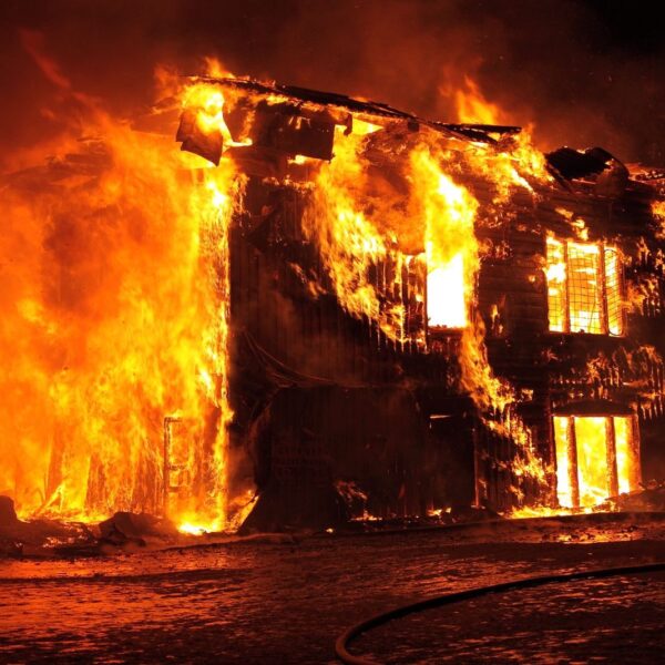 A dramatic nighttime scene of a house engulfed in flames in Tulan, Russia.