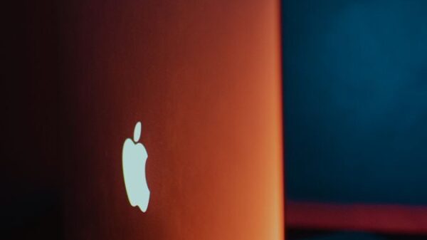Minimalist laptop design featuring glowing Apple logo with dramatic lighting.