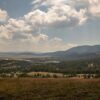 Captivating landscape of Zlatibor, Serbia with lush valleys and rolling hills under a cloudy sky.