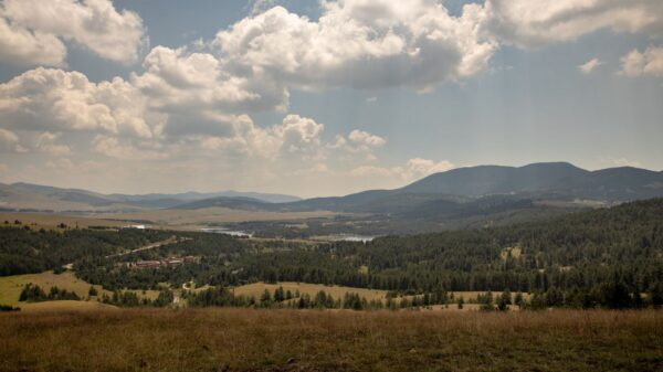 Captivating landscape of Zlatibor, Serbia with lush valleys and rolling hills under a cloudy sky.