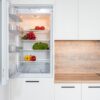 Contemporary kitchen with refrigerator filled with fresh bright tomatoes lettuce and bell peppers