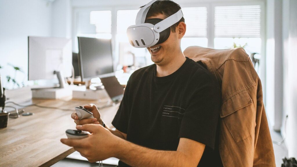 a man sitting at a desk wearing a virtual reality headset